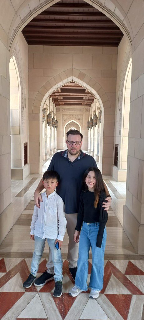 Family tour inside Sultan Qaboos Grand Mosque corridor Muscat