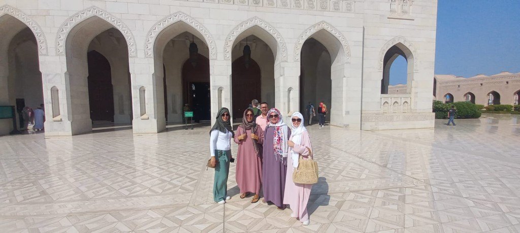 Visitors at Sultan Qaboos Grand Mosque courtyard Muscat