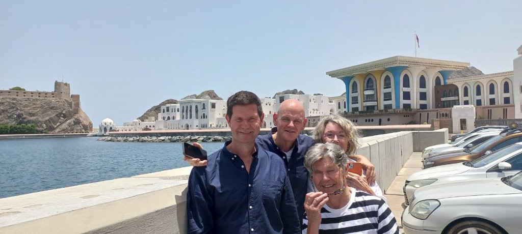 Tourists at Al Alam Palace in Old Muscat with historic forts behind