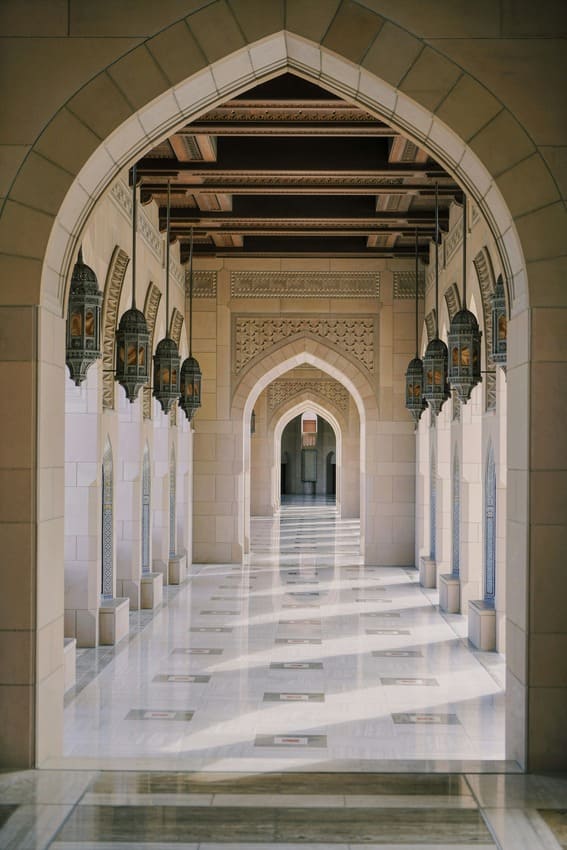 Islamic arched corridor with lanterns in Muscat — architecture before the inland Nizwa tour