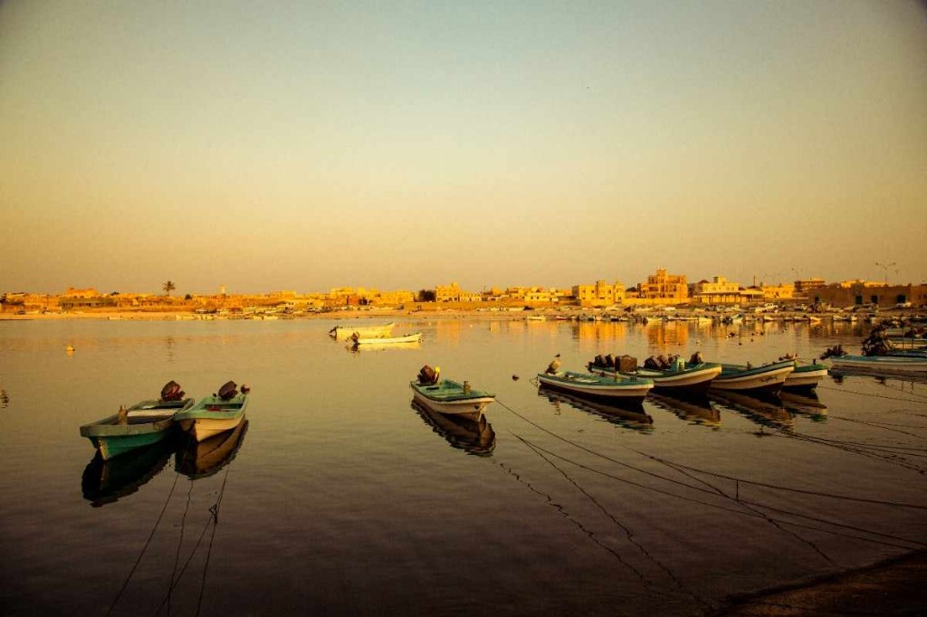 Fishing boats at anchor in a golden-hour harbour on Oman’s eastern coast