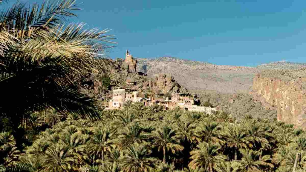 Date-palm village and a stone tower on the inland road between Nizwa and the Jebel Akhdar turn