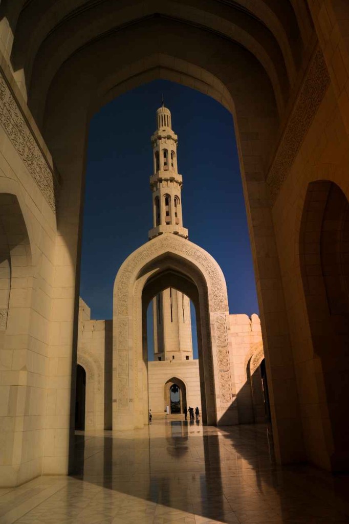 Sultan Qaboos Grand Mosque minaret seen through a carved arch in Muscat