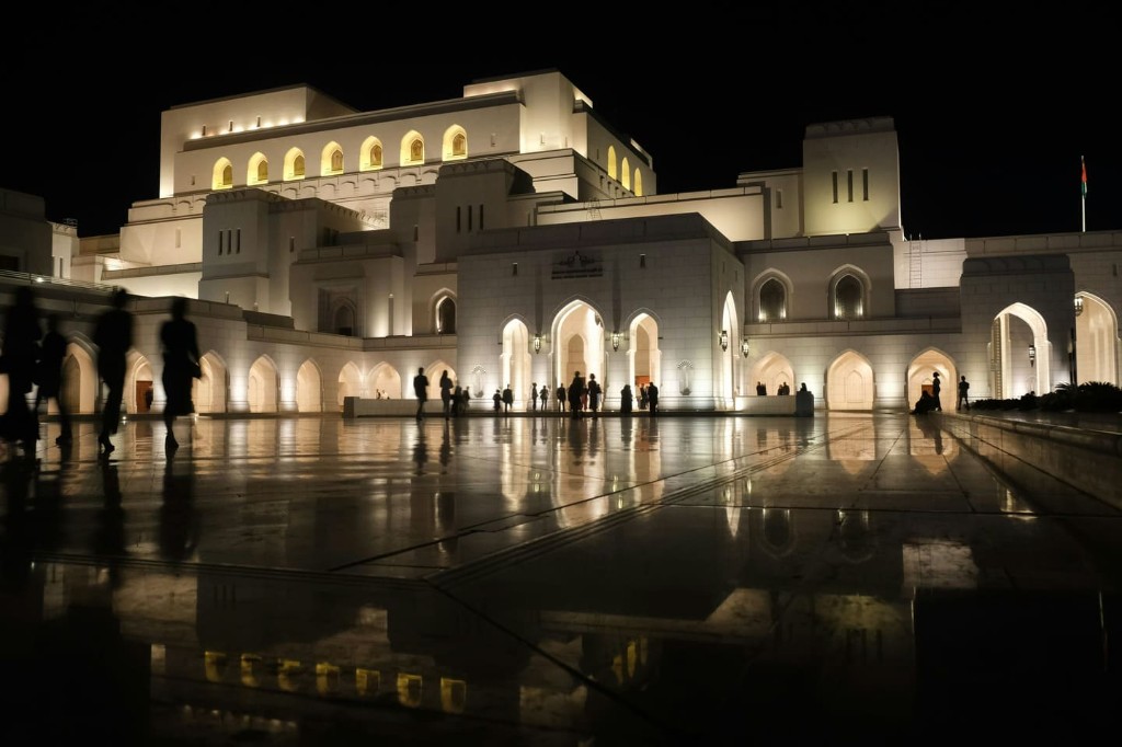 Royal Opera House Muscat at night with marble courtyard reflections